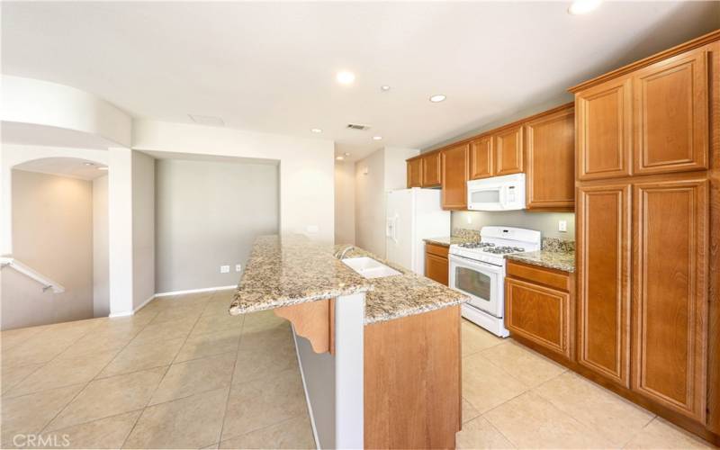 Kitchen area with granite counters and tile flooring.