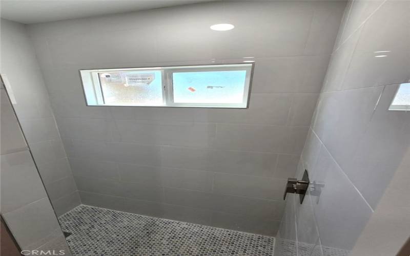 Walk-in shower stall with rain showerhead & wand.