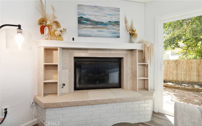 The living room is anchored by a gas fireplace with tile surround and mantel.