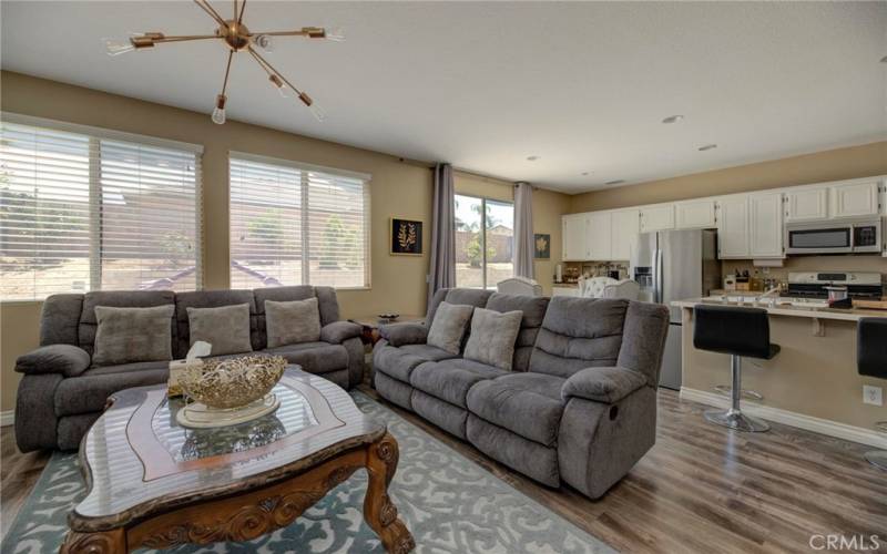 The family room with a view of the kitchen and looking out at the backyard.