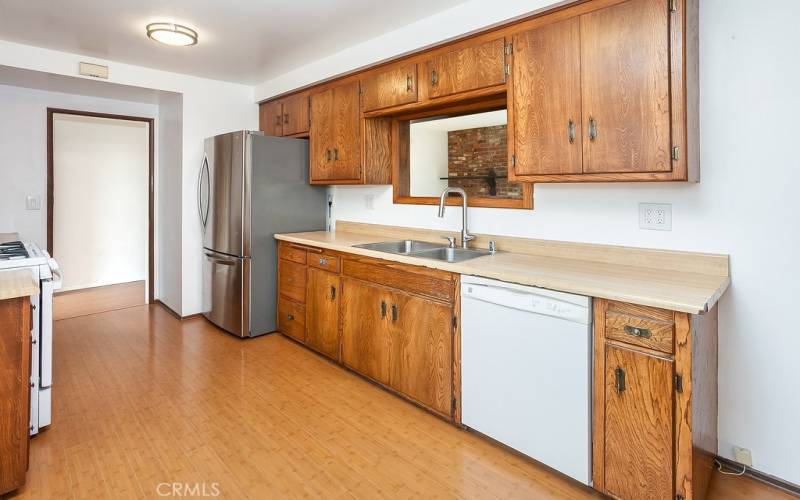 The cook in the family is going to truly appreciate the bright and spacious freshly painted kitchen with its large picture window, rich wood-grained cabinetry, handy pantry, ample counter space, dual basin stainless steel sink, gas range, dishwasher, refrigerator, convenient breakfast nook, and easy-care wood laminate floors.