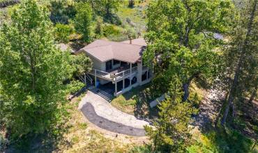 Aerial view of the front deck, stairs lead to front door and carport underneath front deck