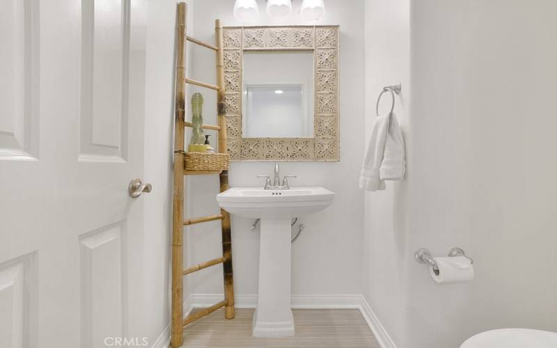 Downstairs 1/2 bath across from the dining room with space-saving pedestal sink and toilet