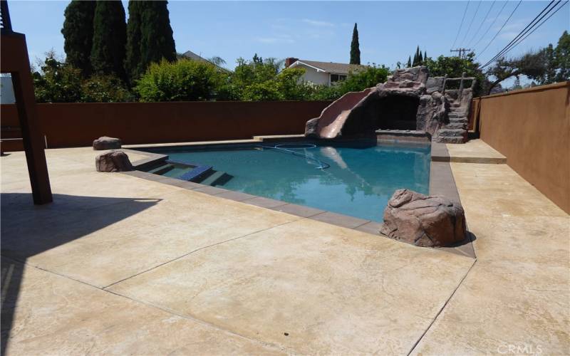 Large Rear Yard with Custom Triangle Shaped Pool, Rock Water Slide, Waterfall and Jacuzzi for everyone to enjoy