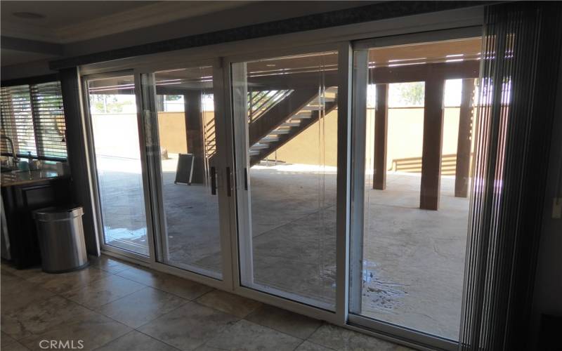 Double Sliding Doors to fully covered Patio with open Patio Deck above.