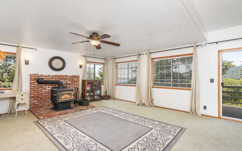 2nd (mid) level family room with wood burning fireplace/stove and a deck