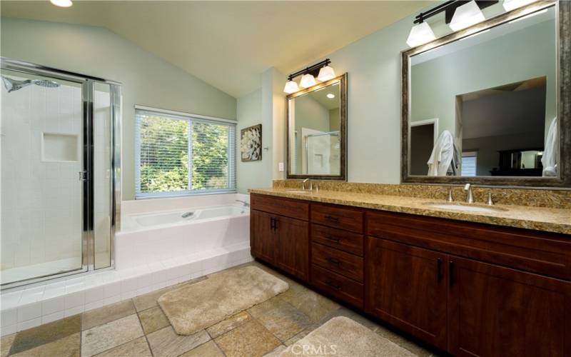 Primary bathroom suite with replaced wood vanity, granite counter tops next to the large custom walk-in closet.
