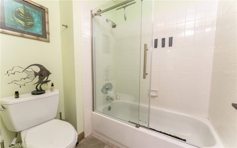 Separate room from the vanity with newer barn door style shower/tub glass doors.