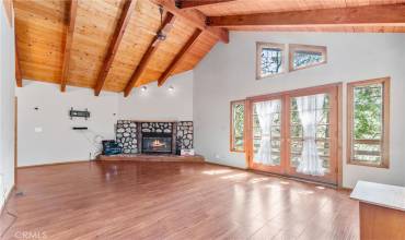 Welcome to 858 Sierra Vista! Large Living Room with gas fireplace, vaulted wood beamed ceilings, frnech doors that open to a deck with views of the mountains and trees!