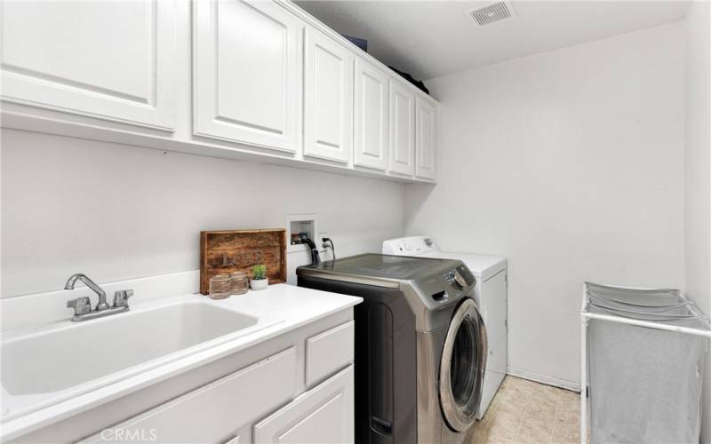 Downstairs laundry room with lots of storage cabinets.