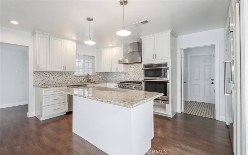 Kitchen has an island and granite countertops