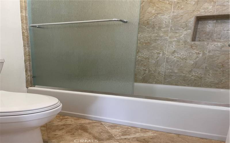 Separate bathing and toilet area with stone tile floors