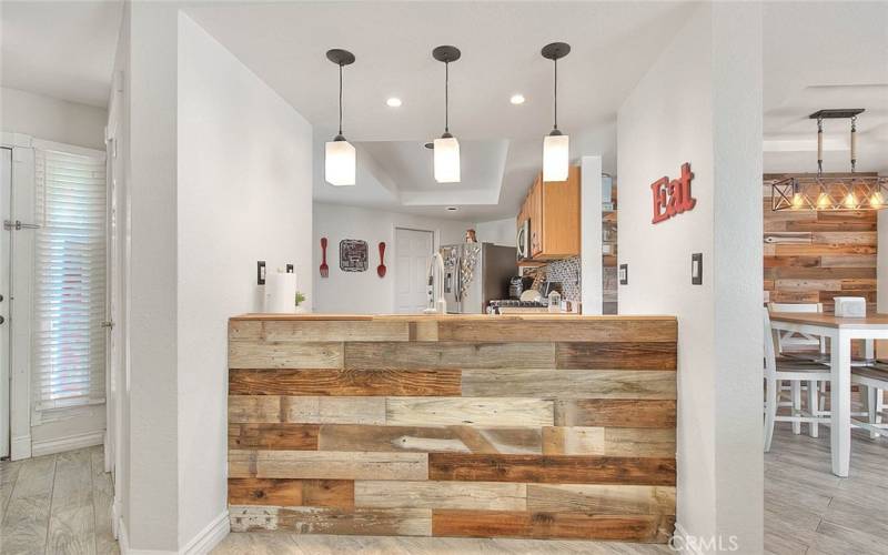 Accenting on living room side of kitchen sink and counter plus decorative pendant lighting