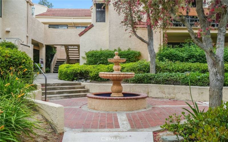 Just walking to and from your condo, the experience is pleasant and peaceful with features like this Spanish style fountain, and all the green foliage throughout.