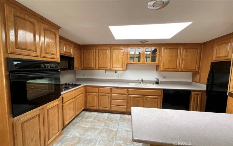 Kitchen has all matching black appliances for sleek look.  Custom oak cabinets and countertops with added peninsula for extra counter and storage space