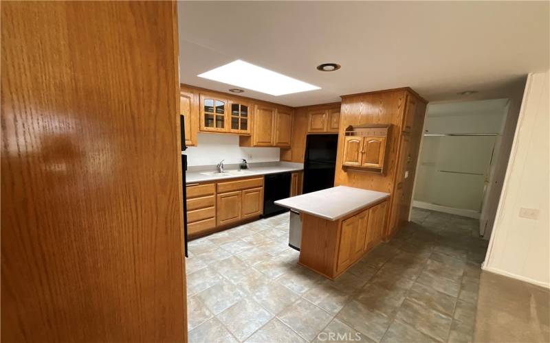Light and bright kitchen with custom oak cabinets and counters, plus oversized skylight opening that adds volume to the space. Plus built in peninsula for extra countertops and storage. Can also be used for informal eating area.