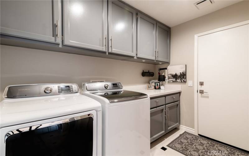 On the first level there is a laundry room with cabinets and quartz countertop.