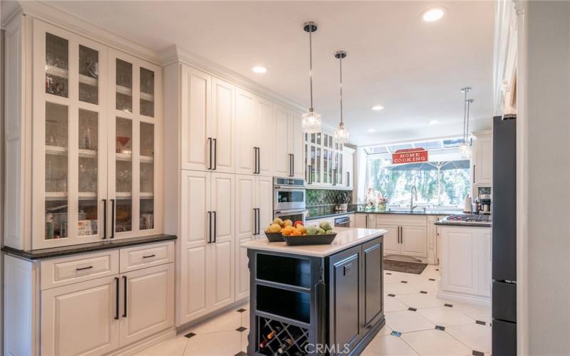 The beautiful kitchen is equipped with white self close cabinets.