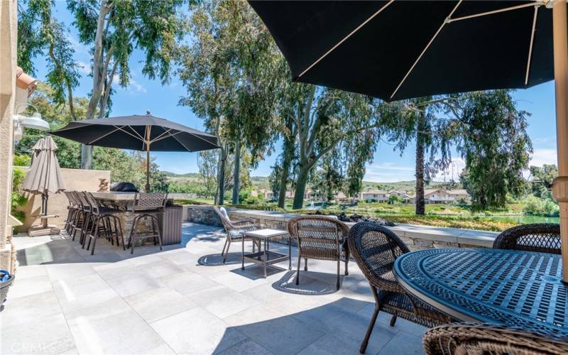 Relax in the entertainer's backyard with a gas fire pit, stone and block fencing, BBQ island with a fridge, warming drawer, and stainless steel grill.