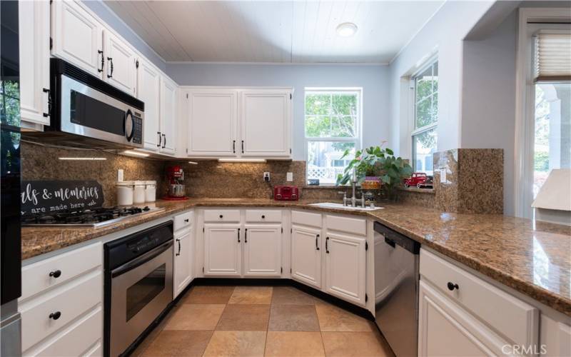 Kitchen is light and bright with picturesque windows and views of the porch area and garden