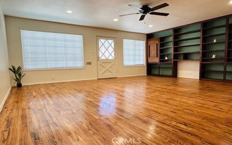 Spacious living room with original hardwood flooring, along with a vintage front door adding charm to the entry of the home!
