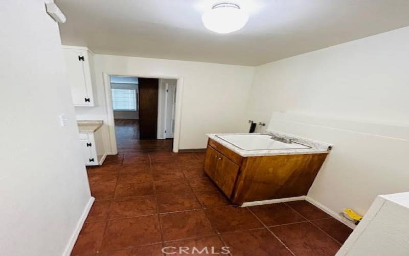 Laundry area near kitchen with a utility sink.
