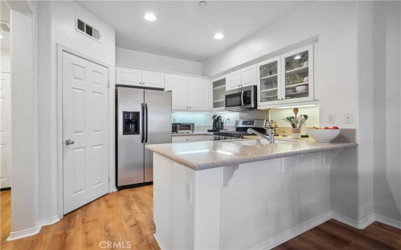 Kitchen features a breakfast bar with granite countertops, stainless steel range, dishwasher, microwave and refrigerator