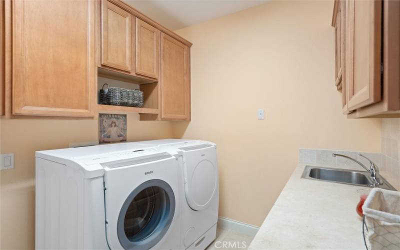 Large laundry room inside with storage and sink