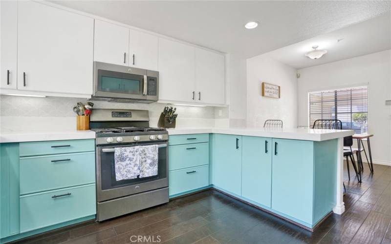 The kitchen has engineered wood floors, two tone cabines, stainless steel appliances and brand new Quartz countertops with backsplash.