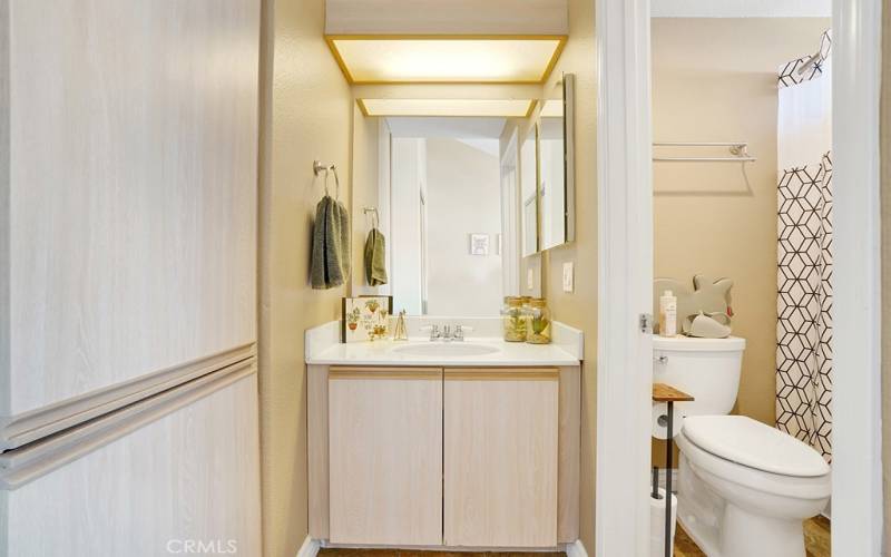 The upstairs guest bathroom has a shower tub combo, a vanity area and toilet.