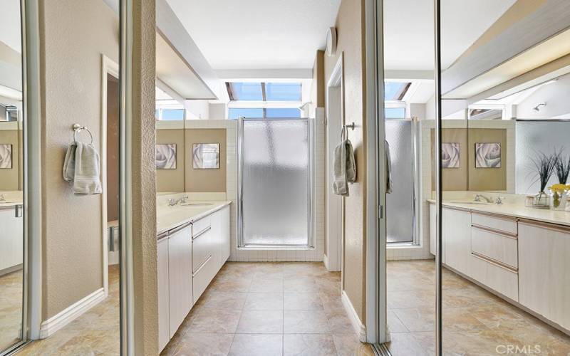The primary bathroom has two mirrored closets, two sinks, a walk in shower and toilet room.