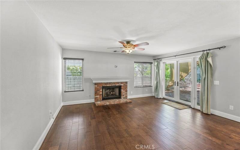 Family room with brick fireplace, ceiling fan and French door to the gorgeous backyard!