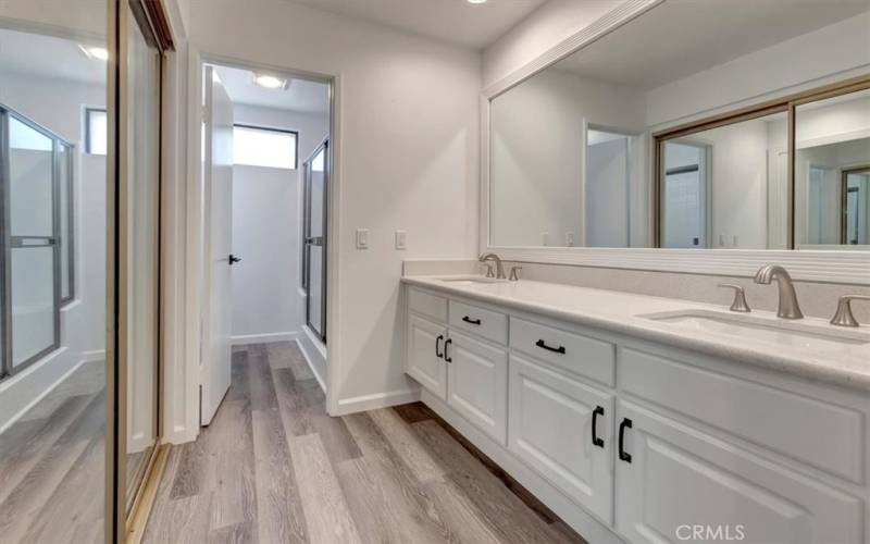 Primary Bathroom with wood flooring, Dual sinks and separate shower area