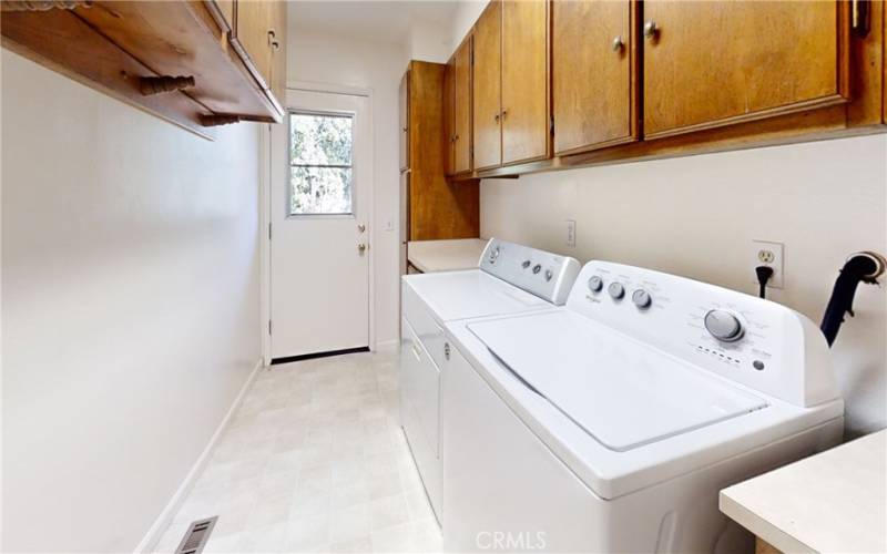 Inside laundry room with plenty of storage and door going out to back deck.