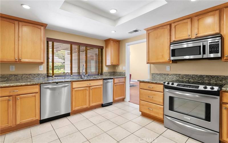 Kitchen has Stainless appliances, granite counters.  The window views the private patio.  Note the recessed lighting, tile floor.  And when you tour, check out the hidden washer and dryer in this kitchen, plus the walk-in pantry.