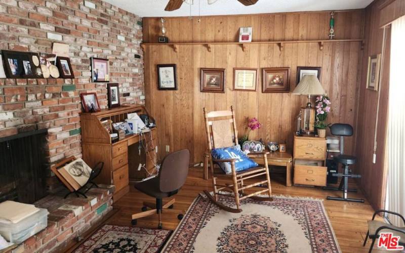 Den with brick and wood paneling