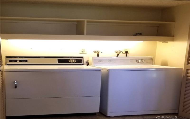 Laundry area with full size washer and dryer. Substantial storage for laundry and cleaning supplies.