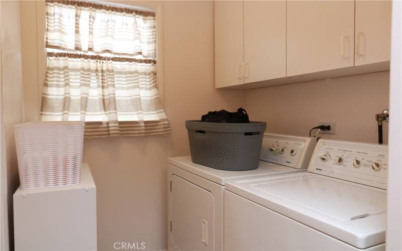 Washer/dryer and storage area off of kitchen. West-facing window.