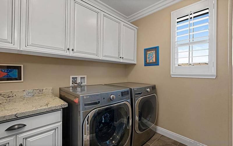 Spacious laundry room with sink and lots of storage