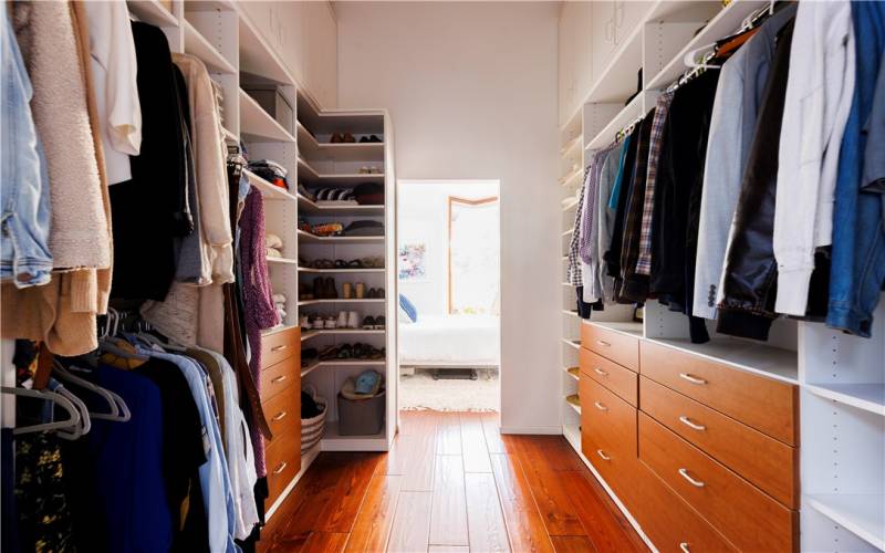 Tall and spacious walk-in closet that leads to the primary bathroom.