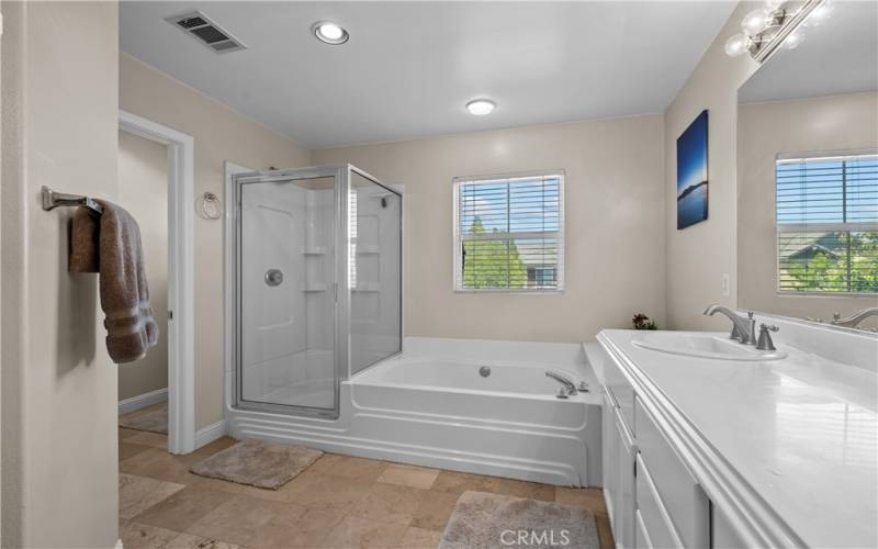 Primary bedroom with soaking bathtub and separate shower.