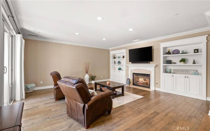 Spacious Living Room off of Kitchen has giant sliders to Courtyard, Cozy Fireplace, and Shelves for your Book or 3D Art Collections.