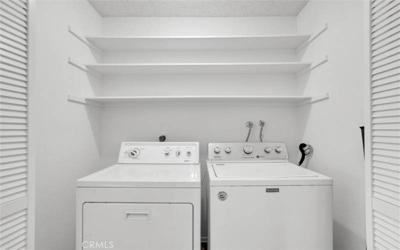 Full size washer and dryer in laundry room.
