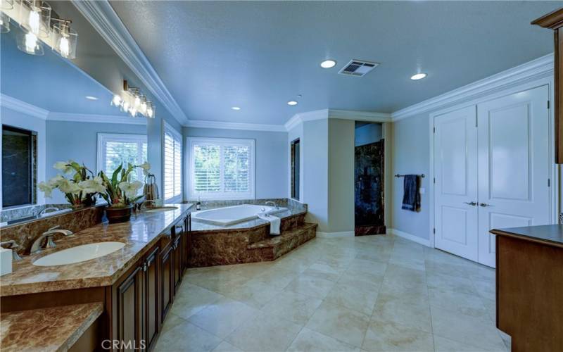 Double door entry to the primary bath, note the large crown molding and easy care flooring.
