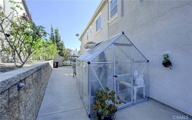 Roomy side yard has a 'green' house.