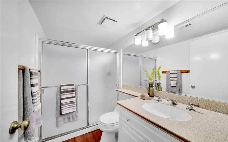 A full bathroom with a walk-in shower and a downstairs bedroom offer added convenience and flexibility.