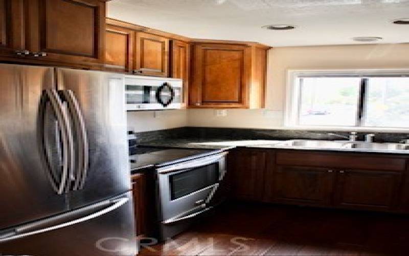 Kitchen with upgraded cabinets, newer fridge and granite countertops