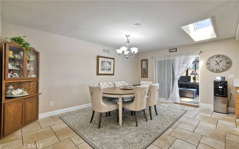 Expansive dining room with skylight, sliding doors lead to the garden room