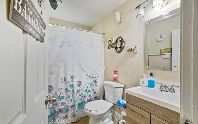 Secondary bedroom with newer vanity and bath-shower combination