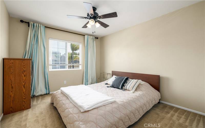 Upstairs secondary bedroom with ceiling fan.